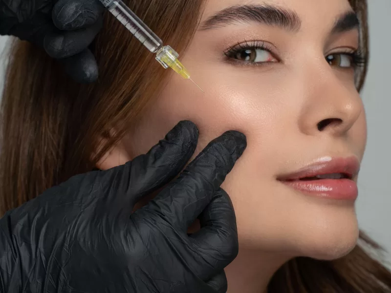 Profissional realizando injeção facial para estímulo de colágeno