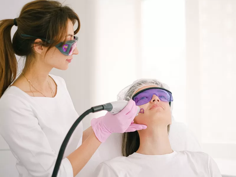 Profissional realizando tratamento a laser para renovação da pele