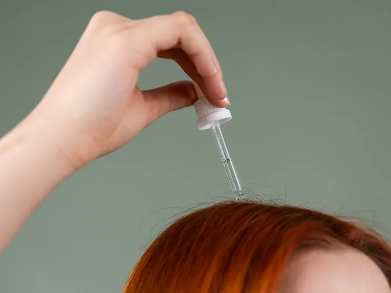 Aplicação de sérum capilar com conta-gotas