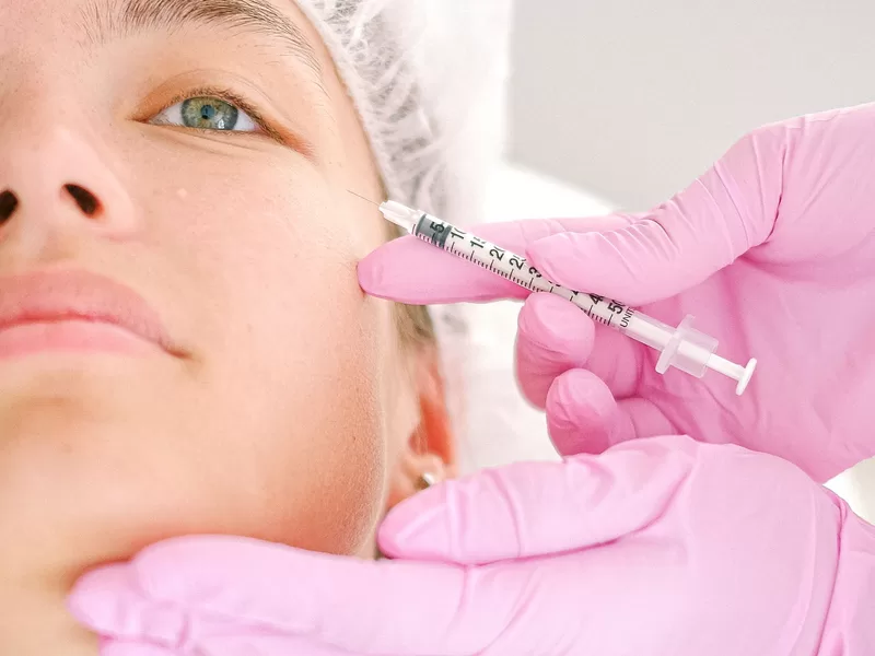 Especialista aplicando injetável facial em paciente